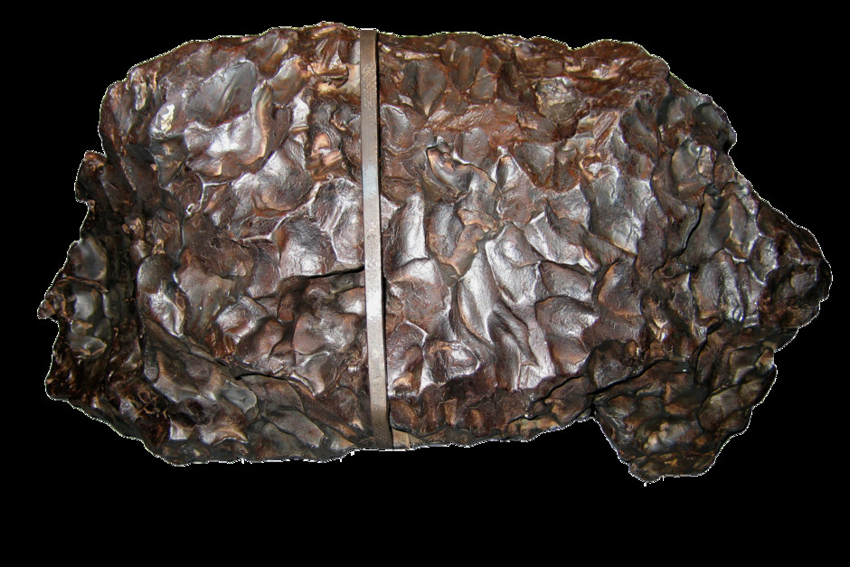 En frilagd bild med järnmeteoriten som visas i utställningen Skatter från jordens inre. Den ser ut som en bucklig rund metallbit.