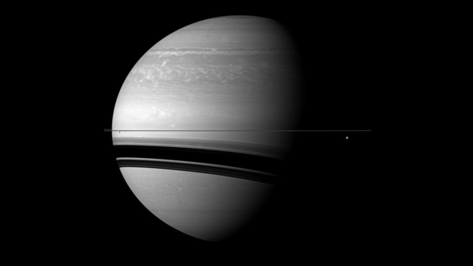 Saturnus med skuggor av dess ringar på planetens yta.