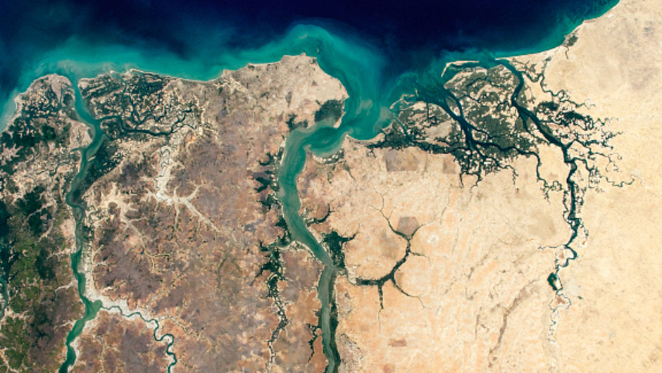 En satellitbild över Gambiafloden och Atlantiska havet, Västafrika. Floden rinner ut i havet.