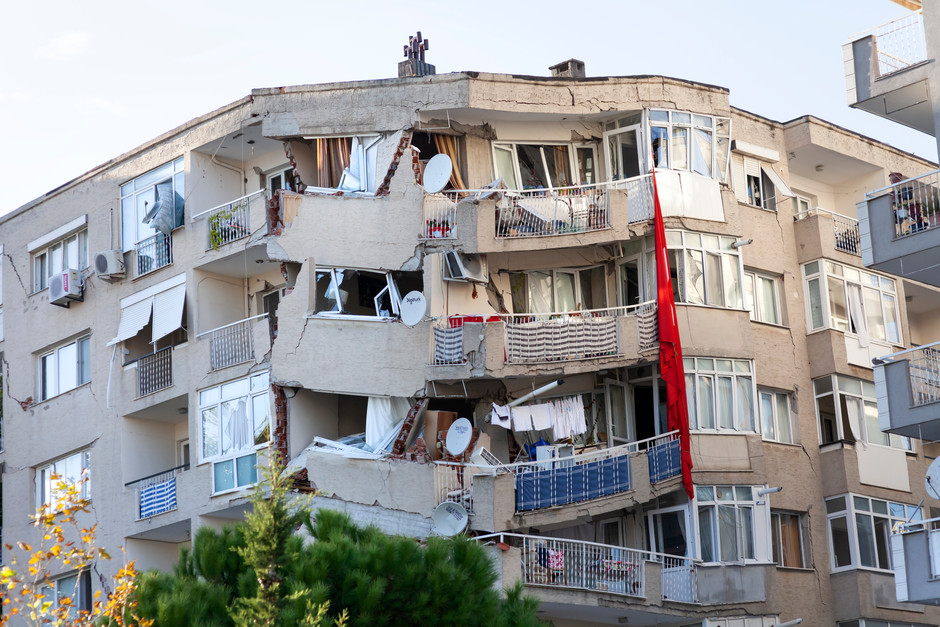 Ett flervåningshus som har kollapsat i jordbävning, gaveln på huset har sjunkit ihop.