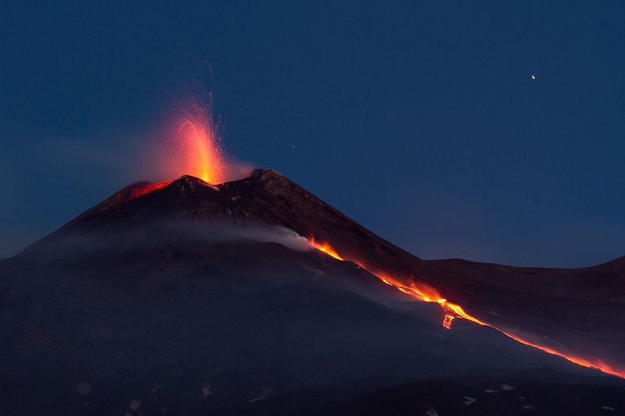 Röd lava sprutar upp i natthimlen över Etna i Sicilien.