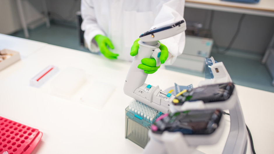 En av museets samlingspersonal står vid ett bord med utrustning i museets DNA-labratorie