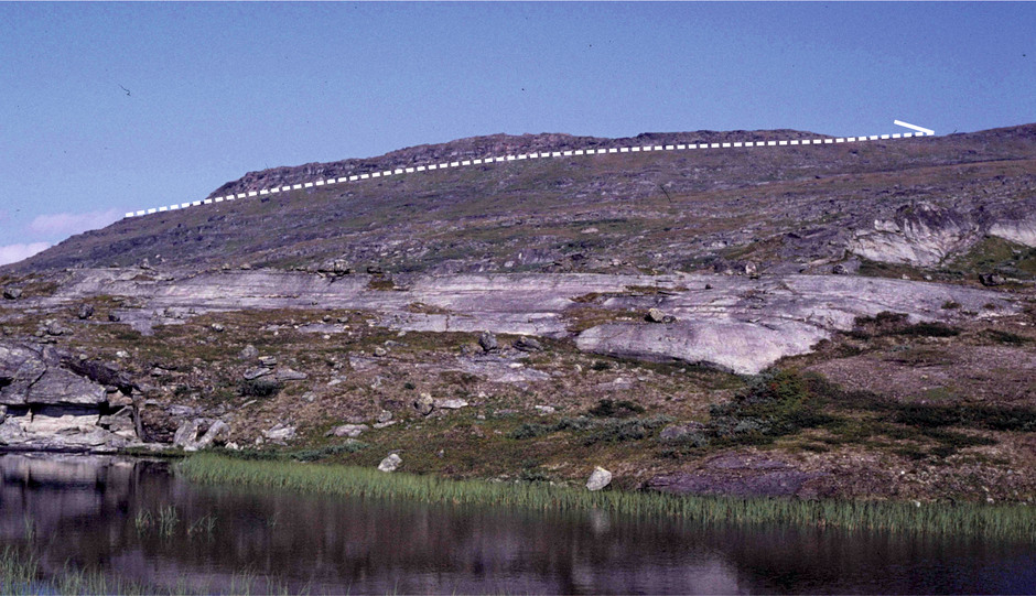 En topografiskt markerad överskjutningszon i de svenska fjällen nära Akkajaure i Norrbotten. Den vita streckade linjen markerar överskjutningsplanet, och den halva pilen överskjutningsriktningen. Huvuddelen av den ovanliggande skollenheten är borteroderad, men en rest av denna bildar en "mössa" på berget.