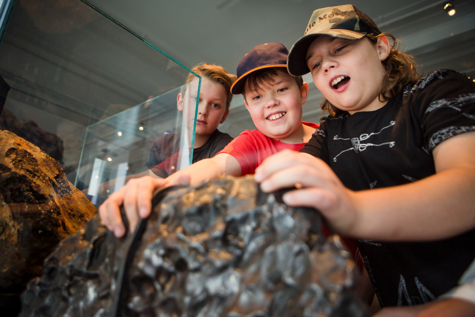 Barn som känner på en meteorit.